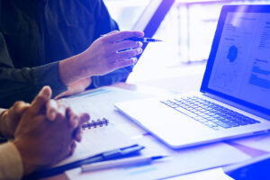 Colleagues reviewing return on investment of conversational AI on laptop screen