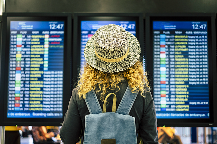 Woman looking at airport display screens