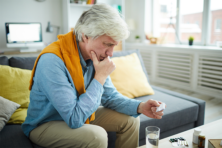 Elderly man reading medication label